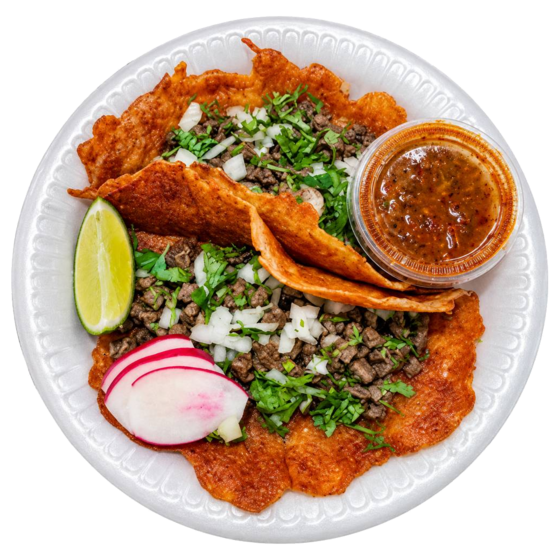 Three street tacos with lime, radish and salsa on a white plate