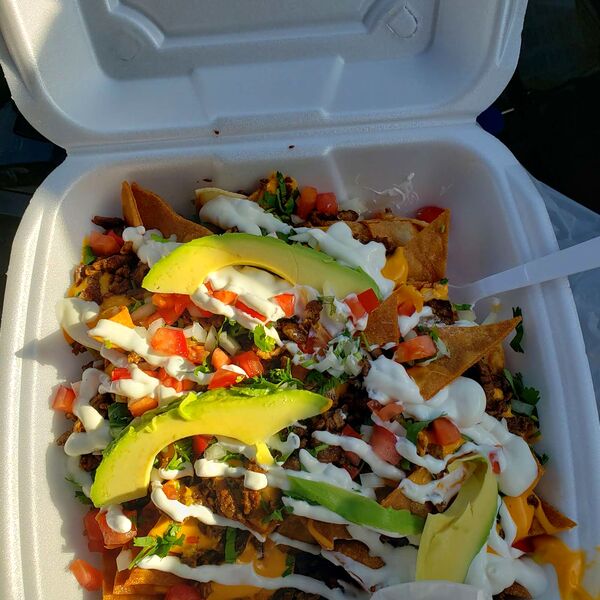 Nachos supreme with avocado slices and sour cream