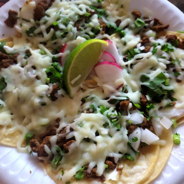 Street tacos with cilantro, onion, cheese and a lime wedge